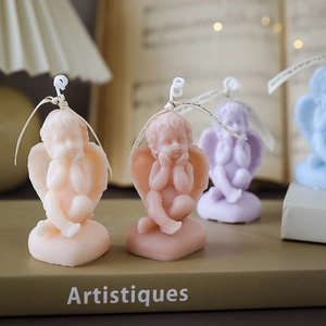 Four angel-shaped scented soy candles in beige, pink, purple, and blue colors