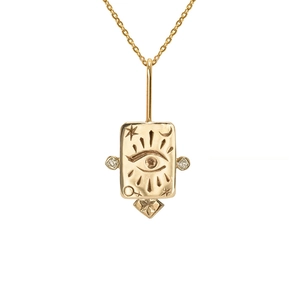 Macro detail of gold tarot necklace pendant featuring moon, star, and gemstone inlays