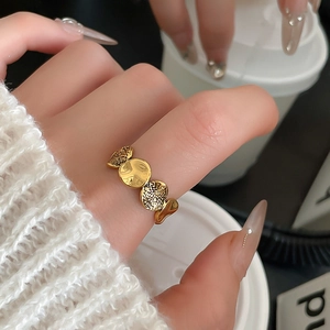 Detail eines goldenen asymmetrischen Blumenrings mit Hammerschlag-Textur