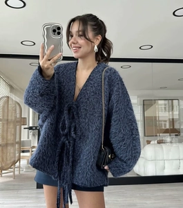 Detail of navy blue oversized cardigan featuring tie-up front and soft fuzzy knit texture