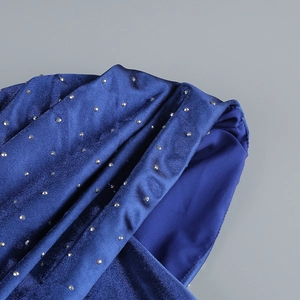Close-up of royal blue velvet evening gown with shimmering silver rhinestone details