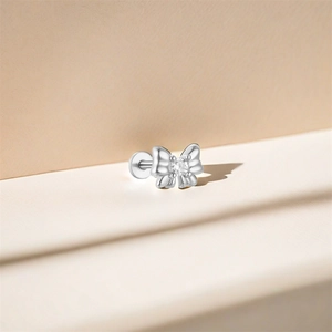 Close-up of s925 silver bow stud earring with a clear round gemstone center