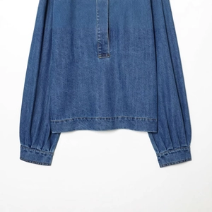 Chemise classique en jean bleu pour femmes avec manches lanternes sur fond blanc