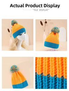 Detail of color-block knit beanie showing rib texture and orange blue pompom