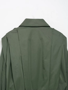 Detail der armee-grünen Jacke mit schickem Umlegekragen und geschichteten Rückenfalten