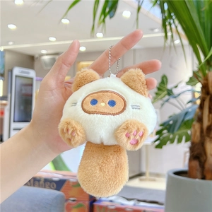 Close-up of a brown and white plush cat keychain with a metal bead chain accessory
