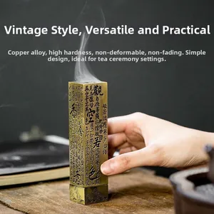 Detail of hand placing brass incense burner with Heart Sutra engraving on tea mat