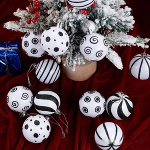 Close-up of black and white glitter Christmas ornaments on red velvet fabric