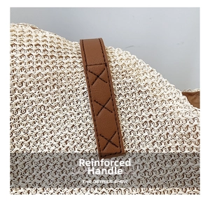 Close-up of reinforced leather handles with cross stitching on woven straw tote bag