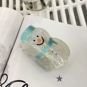 Vue détaillée d'une pince à cheveux bonhomme de neige blanc nacré et bonnet menthe