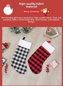 Detail of red and white buffalo plaid Christmas stockings with plush trim on wood floor