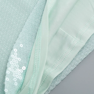 Detalle del vestido de lentejuelas verde menta con tela de malla y costura fina