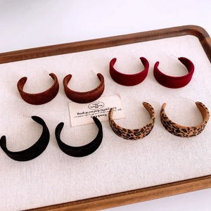 Détail de quatre créoles en velours en rouge, marron, noir et imprimé léopard