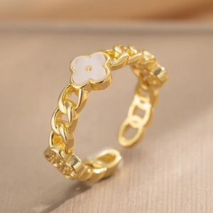 Gold adjustable chain ring featuring white clover element on champagne texture background