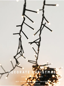 Close-up of warm white LED Christmas lights with black wire for festive holiday decoration
