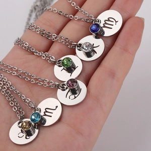 Handheld stainless steel zodiac necklaces with colorful birthstones and engraved symbols