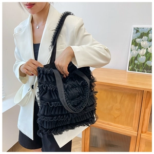 Detailed view of the black ruffled mesh tote bag with a sweet cake skirt design.