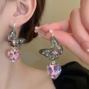 Close-up of butterfly earrings featuring purple heart crystal and shimmering diamond wings