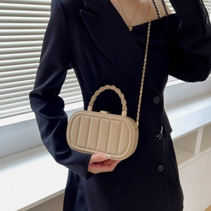 Stylish khaki textured box bag with chain strap and woven handle shown on model