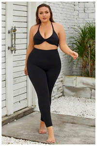 Détail d'ensemble de yoga noir avec haut dos nu torsadé et legging gainant taille haute