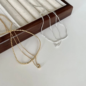 Detail of minimalist 925 silver beaded necklaces in gold and silver finishes