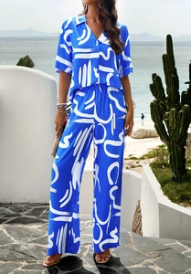 Detail of vibrant blue summer two-piece set featuring abstract white floral print and wide-leg pants