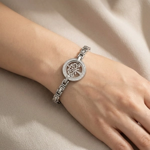 Macro shot of silver Tree of Life charm bracelet with sparkling crystals on wrist
