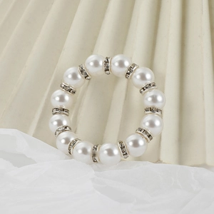 Elegant napkin ring with faux pearls and sparkling crystal spacers on white fabric