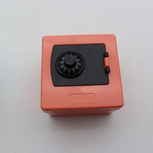 Close-up of orange plastic money box with black combination lock dial and hinges