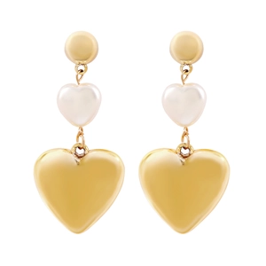 Close-up of golden and white triple-layered heart drop earrings with faux pearls