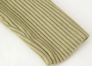 Close-up of the light green ribbed knit texture and cuff craftsmanship of the cardigan