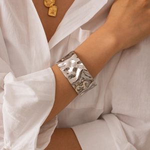 Minimalist silver wave textured wide cuff bracelet made of polished stainless steel
