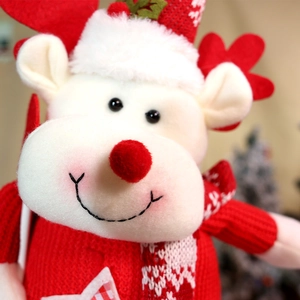 Close-up of a Christmas reindeer plush with knitted sweater and festive star detail