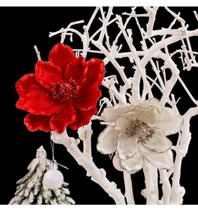 Close-up of velvet Christmas flowers with gold glitter hanging on white branches