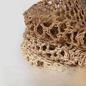 Detailed macro view of woven hollow crochet pattern on natural paper straw hats