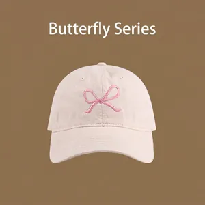 Close-up of light beige sun hat featuring detailed pink bowknot embroidery and clean stitching