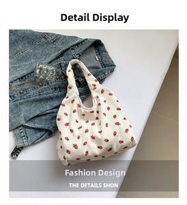 Detail view of white corduroy tote bag featuring an all-over red strawberry print