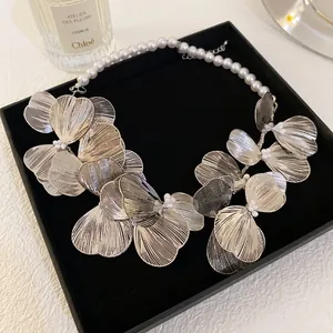 French style hollow metal flower necklace with white pearls on a black velvet jewelry box