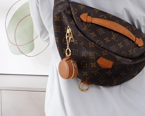 Close-up of monogram pattern crossbody bag with brown round coin purse detail