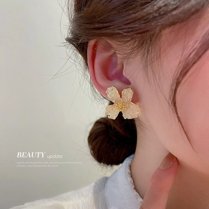 Close-up of elegant gradient crystal flower stud earring worn on a model's ear