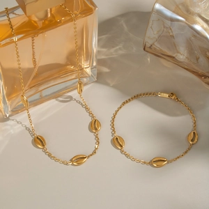 Detail shot of the gold coffee bean chain link showing S.steel material hallmark