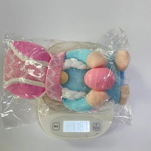 Detalle de un gnomo de Pascua con orejas de conejo y huevo rosa en bolsa protectora