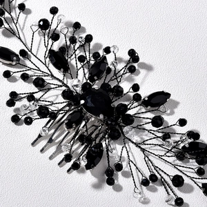 Close-up of handmade bridal hair comb with emerald green crystals and black wire beadwork