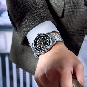 Men's silver quartz watch with black dial and date display in a business suit context
