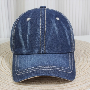 Detail of dark blue denim baseball cap with yellow contrast stitching and six-panel structure