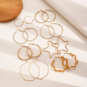 Détail de 8 paires de boucles d'oreilles créoles dorées avec étoiles et perles