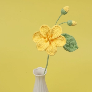 Bouquet de fleurs jaunes tricoté à la main dans un vase en céramique blanche