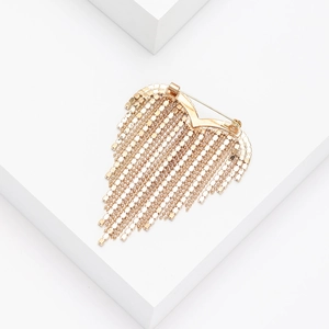 Close-up of elegant gold heart brooch featuring long hanging metallic tassel chains