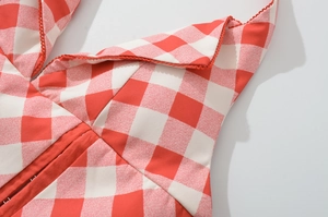 Detailed macro view of red and white plaid fabric with delicate red lace trim edging