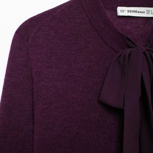 Haut élégant en maille violette avec col rond et détail de nœud en ruban de soie